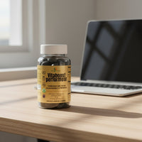 pot de gummies vitaboost perfomeur posé sur un bureau près d'un ordinateur